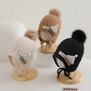 Kids knitted ear-protection hats with pom-pom and chin straps in three warm colors