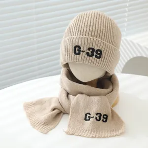 Detailed knit texture of beige ribbed kids hat and scarf set with G-39 letter embroidery
