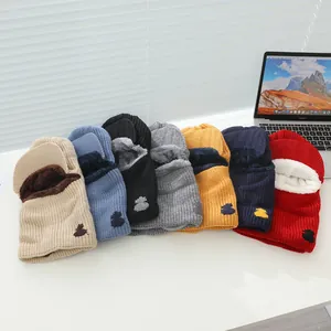 Close-up of thick knitted balaclava hats with plush fleece lining and rabbit embroidery