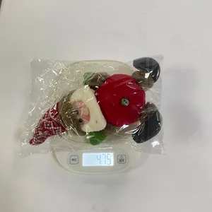 Detail shot of a plush Christmas doll on an electronic scale showing 47.5g weight