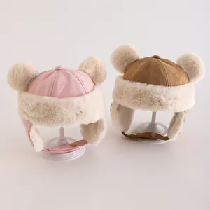 Detail von warmen Baby-Wintermützen mit Pompons, Wildlederimitat und dickem Fellfutter