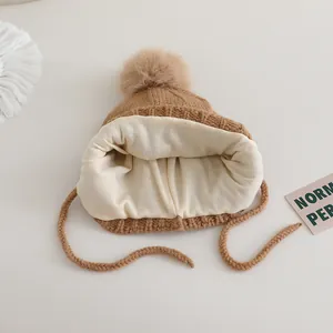 Brown knit winter hat for kids with pompom, ear flaps and warm plush lining