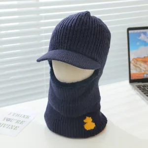Close-up of winter knitted thermal hood with visor and cute yellow duck decoration
