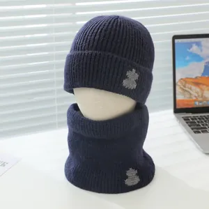 Details der Strickstruktur von dunkelblauem Kinder-Beanie und Schal-Set mit Cartoon-Patch