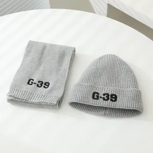 Detail view of gray ribbed knit beanie and scarf set with black G-39 letter embroidery
