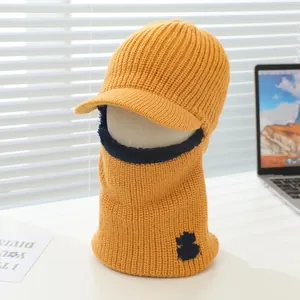 Detail of yellow knitted balaclava with brim and navy fleece trim for kids