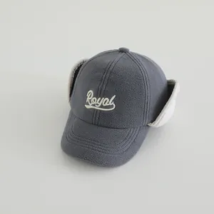 Dettaglio del ricamo Royal sul cappellino in pile grigio scuro con paraorecchie