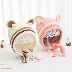 Dettaglio di cappelli in maglia per neonati con orecchie da orso a righe beige e rosa