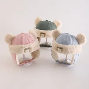 Plush winter baby trapper hat with bear patch and double pom poms in multiple colors