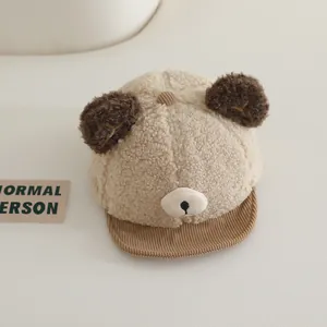 Close-up of soft beige plush sherpa fabric and brown corduroy brim on a baby winter hat