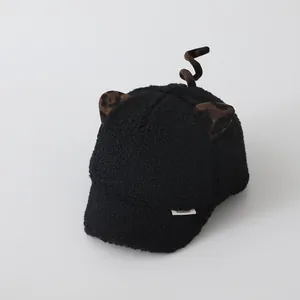 Detail of black faux shearling baseball cap with leopard ears and spiral tail accent