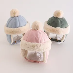 Drei Baby-Wintermützen in Rosa, Blau und Grün mit Kunstpelz-Bommeln und Ohrenschutz