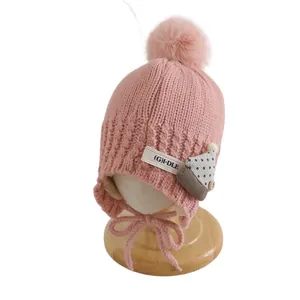 Pink knit winter hat for kids with pompom, earflaps and (G)I-DLE embroidered tag