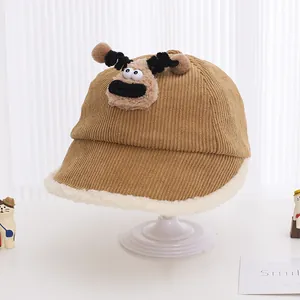 Detail of brown corduroy kids winter bucket hat with white fleece brim and monster patch