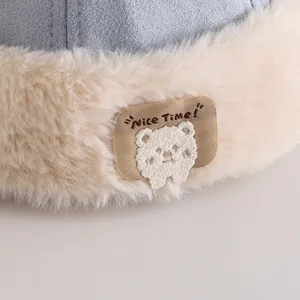 Toddler winter earflap hat with cute bear patch and fluffy white faux fur trim detail