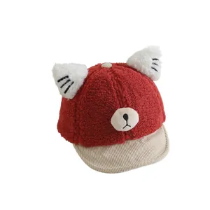 Cute red plush baby baseball cap with bear face and ears on a clean white background