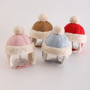 Detailansicht von Baby-Wintermützen in vier Farben mit Plüschbesatz und Ohrenklappen mit Riemen