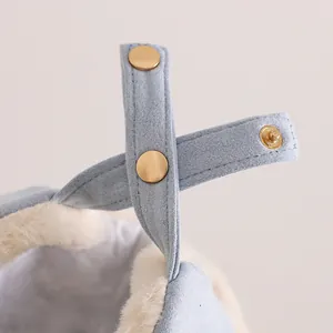 Detail view of light blue winter hat showing premium white faux fur and golden snap buttons