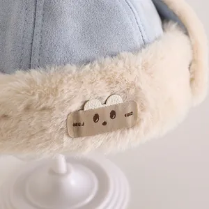 Detail van de wintermuts voor baby's met pluche voering en schattig berenborduursel