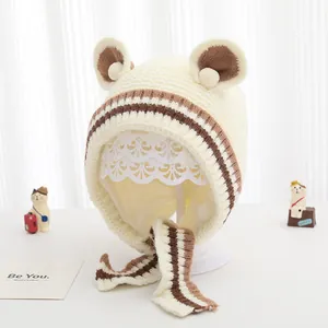 Dettaglio del cappello in maglia per neonati con orecchie da orso e morbida fodera a righe