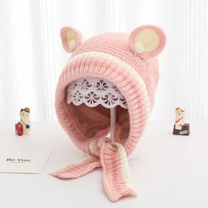 Dettaglio del cappello in maglia rosa per neonati con orecchie da orso e lacci sottogola