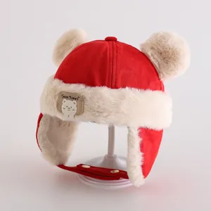 Close-up of red winter earflap hat with plush cream lining and bear patch detail