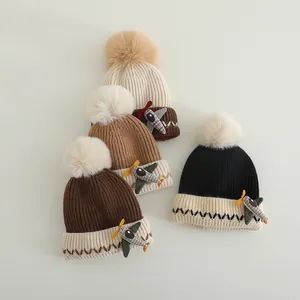 Winter gebreide babymutsen met schattige vliegtuigpatch en zachte pompon van imitatiebont