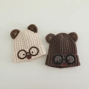 Kids knitted beanie hats with bear ears and glasses design in cream and brown colors