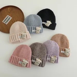 Flat lay of colorful knitted beanies with coffee cup patch and Honey Bear label
