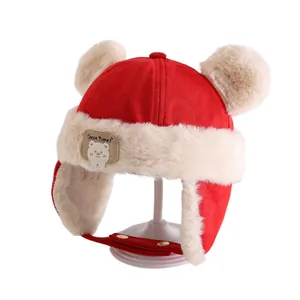 Red winter toddler trapper hat with fluffy pom-poms and cute bear badge for cold weather