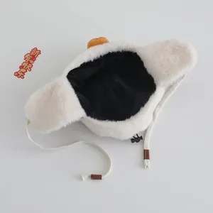 Detail of warm winter baby trapper hat in cream faux fur with ear flaps and festive decor