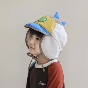 Details einer Kinder-Wintermütze mit Dinosaurier-Deko, Plüschfutter und Ohrenklappen