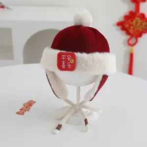 Detail of red festive baby winter hat with white faux fur lining and auspicious text