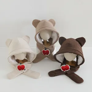 Close-up of plush children earflap hats with corduroy fabric and cute strawberry accents