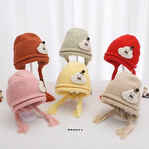 Detailed grid of knitted baby earflap hats with cute bear patches and tassel ties