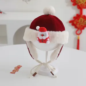 Detail of red festive baby winter hat with plush Santa doll and warm earflaps