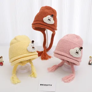 Detail of baby winter knit hats with cute teddy bear patches and cozy ear flaps