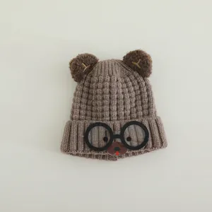 Detailed knit texture of a brown children's bear hat with cartoon glasses and 3D ears