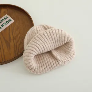 Detail of chunky ribbed knit texture on a cozy beige winter beanie with natural lighting