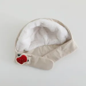 Close-up of baby winter hat featuring plush rabbit fur lining and cute strawberry detail
