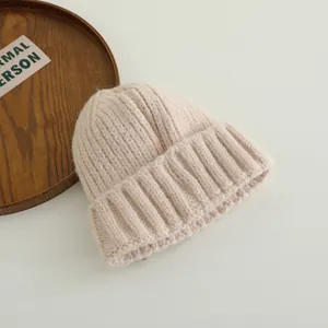 Close-up of cream chunky rib-knit beanie showing soft wool blend texture and wide cuff