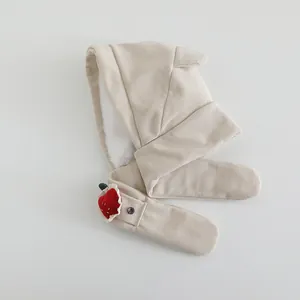 Detail of beige fleece-lined kids earflap hat with cute strawberry pocket and scarf