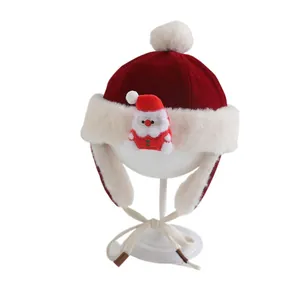 Festive red velvet baby Christmas hat with white faux fur trim and Santa Claus plush toy