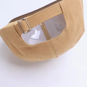 Detalle de la hebilla metálica ajustable y textura de sarga en la gorra kaki para niños