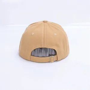 Detalle de la hebilla de metal ajustable y los ojales de la gorra de béisbol kaki