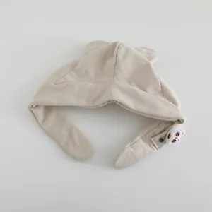 Detail of baby earflap hat in beige corduroy with cute lion embroidery and cozy lining