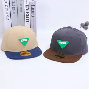 Detalle de gorras hip-hop bicolor con parche triangular verde y pegatinas doradas