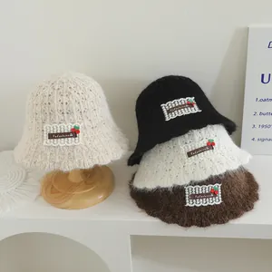 Détail de bobs en tricot avec écusson fleur en dentelle et broderie cerise pour enfant