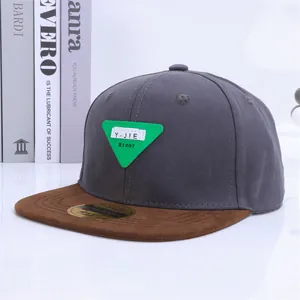 Detalle de la corona gris y visera plana marrón con textura de gamuza de la gorra