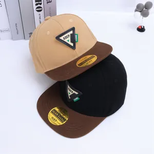 Detalle de gorras hip-hop bicolor con parche triangular de cuero y visera plana de moda
